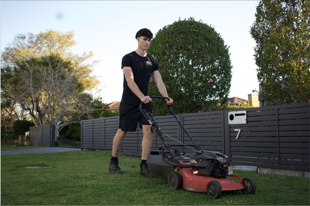 Max from To The Max Lawns mowing a freshly cut green lawn